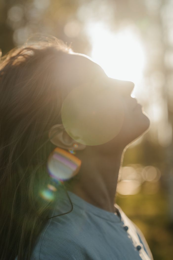 A tranquil outdoor portrait of a woman basking in the warm glow of the summer sun.